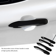 Glossy black ABS door handle cover mounted on white Toyota car exterior door
